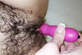 Hairy pussy plays with a vibrator and gets an orgasm in the bathroom